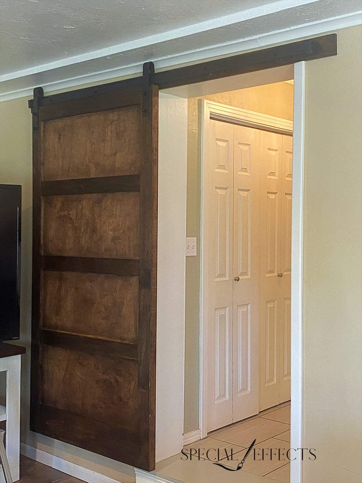 custom rustic wood barn door installed on sliding track covering hallway opening dark stain farmhouse home