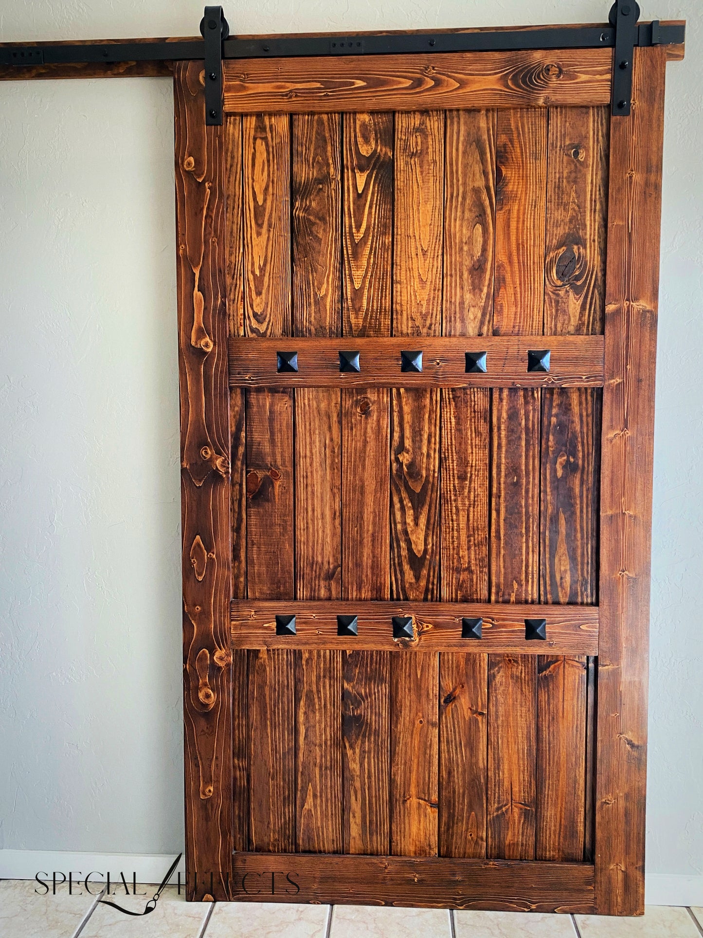 custom wood barn door open position showing pantry dark stain rustic traditional style black hardware