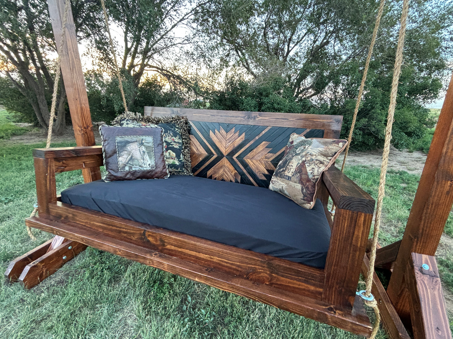 handcrafted wood porch swing dark walnut stain geometric backrest with cushion rope hardware Western farmhouse