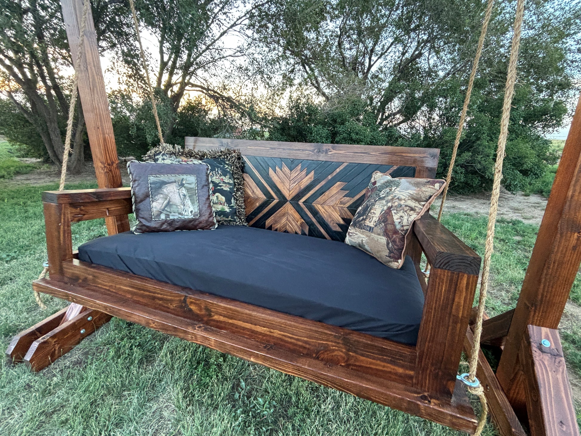 handcrafted wood porch swing dark walnut stain geometric backrest with cushion rope hardware Western farmhouse