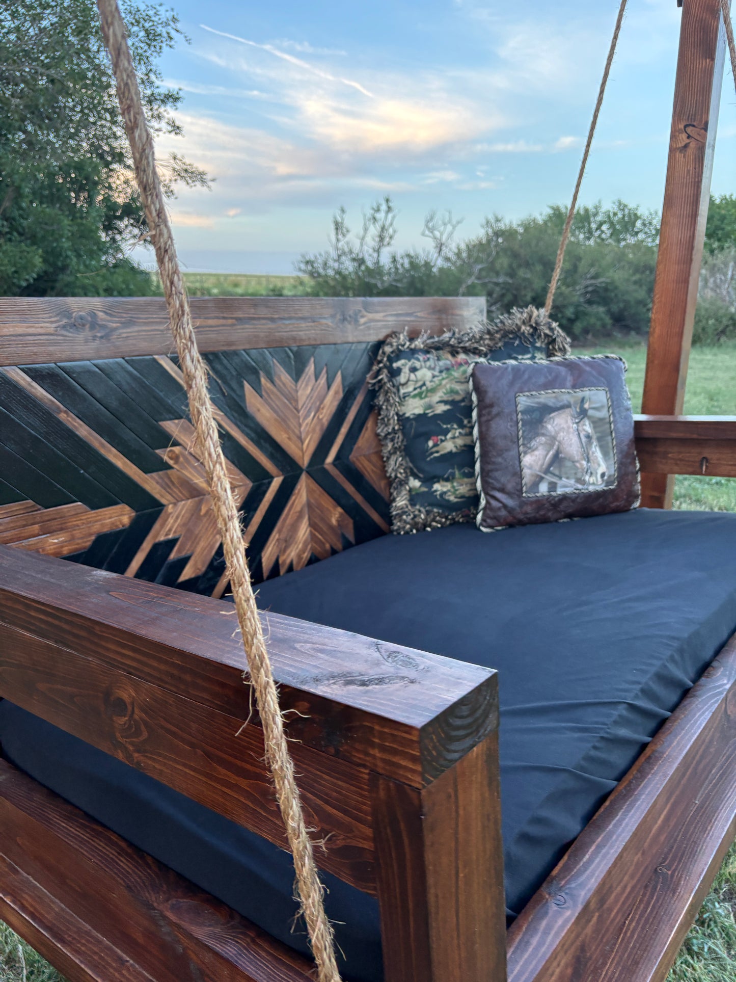 custom wood porch swing detail shot rope hardware solid wood frame dark stain cushion Western farmhouse outdoor